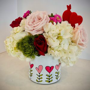Hydrangeas and 1/2 dozen mixed pink and red roses with pink and green accents in heart floral ceramic pot